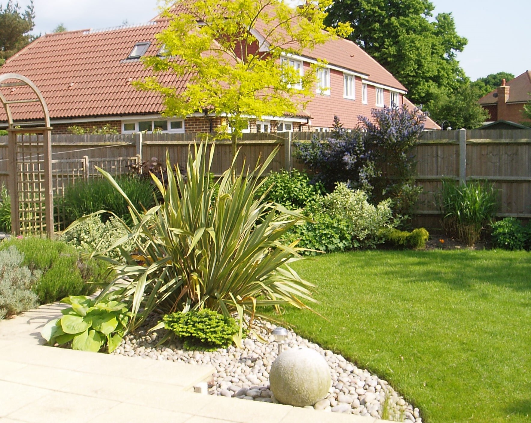 A strong architectural look around this modern garden room, the vegetable parterre garden just visible through the archway