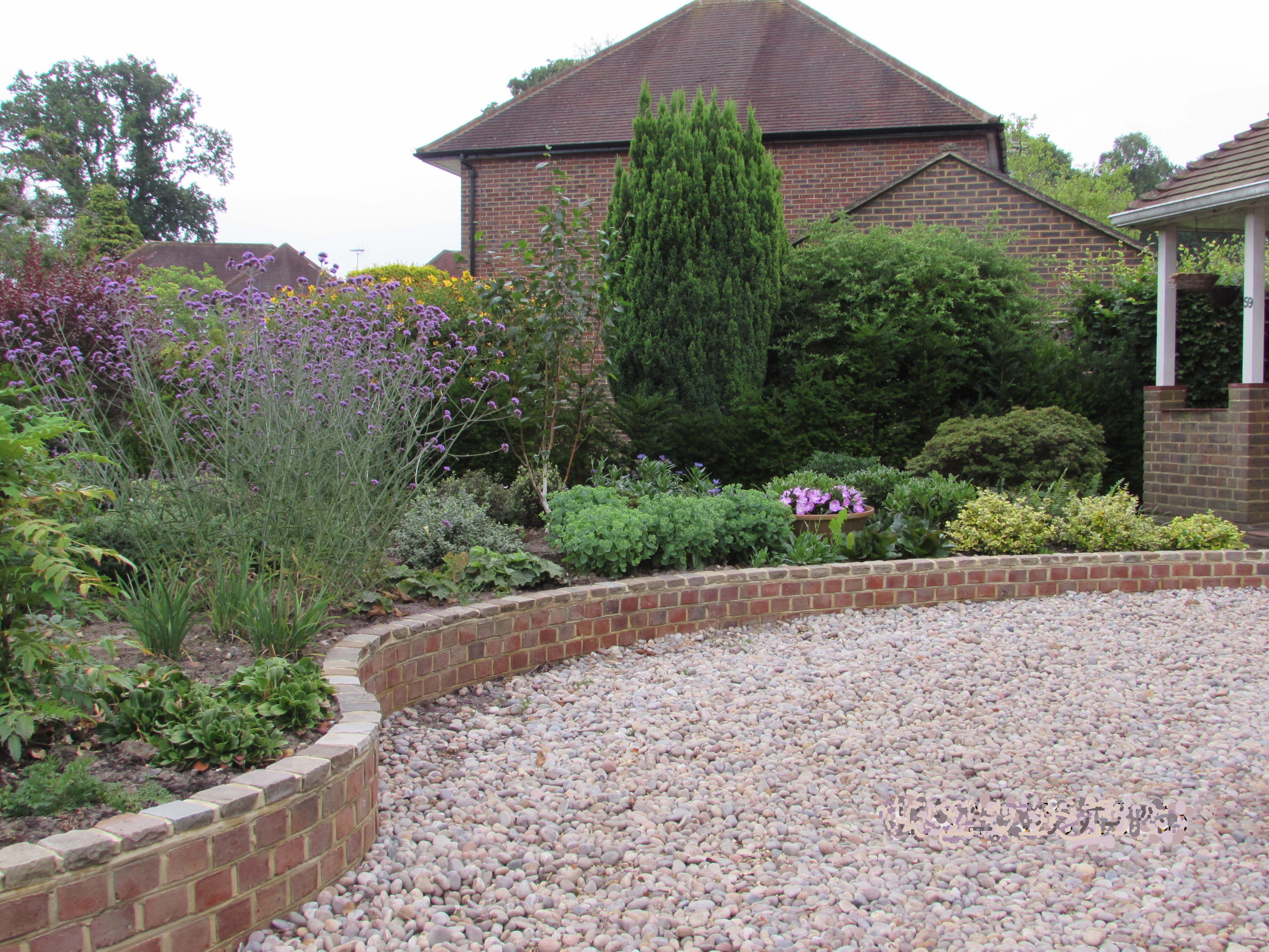 A serpentine low brick wall topped with sandstone